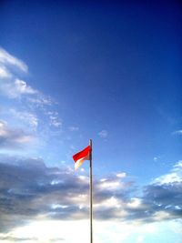 Low angle view of flag against blue sky