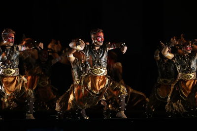 People dancing against black background