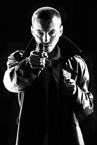 Portrait of man holding guns black background