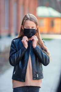 Girl wearing mask while standing outdoors