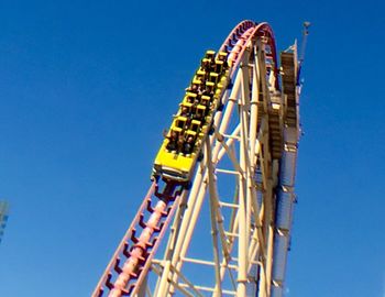 Low angle view of ferris wheel against blue sky