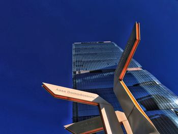 Low angle view of modern building against clear blue sky