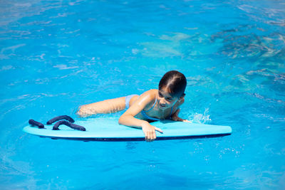 Full length of shirtless boy swimming in pool
