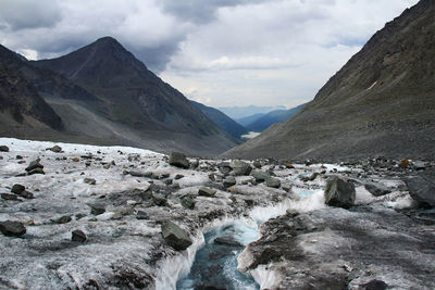 View from the glacier to the mountain valley in altai in cloudy weather, the sky with clouds