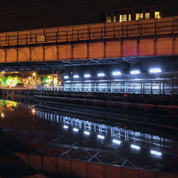 Illuminated bridge over river at night