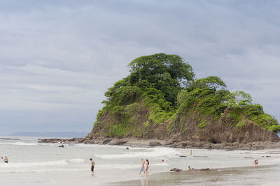 People on beach against sky