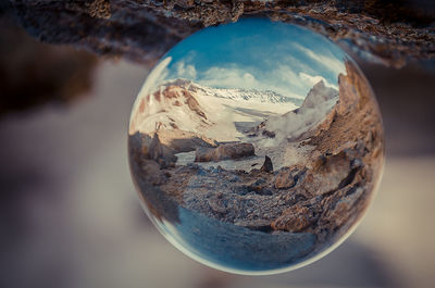 Close-up of crystal ball against mountain