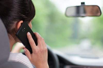 Woman talking on mobile phone in car