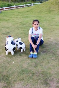 High angle portrait of woman sitting on field by toy animal