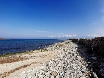 Scenic view of beach against blue sky