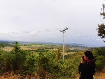 Man standing on mountain road against sky