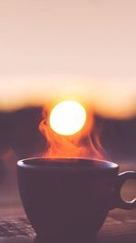 Close-up of drink against sky during sunset