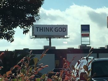 Low angle view of sign board against sky