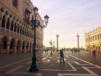 People at piazza san marco against sky during sunset
