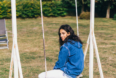 Woman sitting on swing at playground