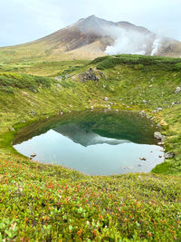 Scenic view of crater lake and mountains against sky