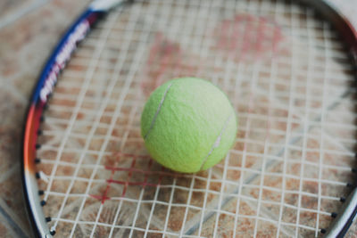 High angle view of tennis ball on tennis racket 