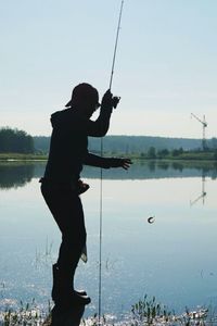 Side view of a man fishing in calm lake