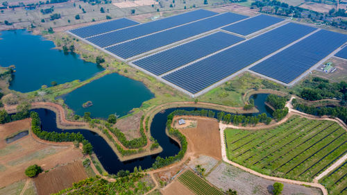 Solar panels farm between agriculture fields in aerial view. in thailand