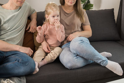 Portrait of couple sitting on sofa at home