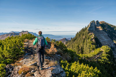 Woman hiking on footpath in alpine landscape in autumn, osterhorn mountain range, salzburg, austria