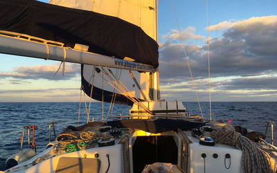 Sailboat sailing on sea against sky