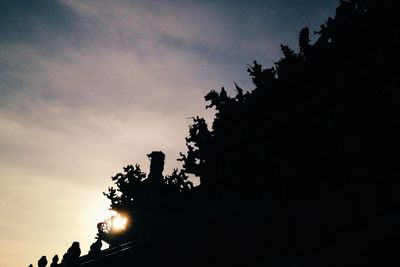 Low angle view of silhouette trees against sky at sunset