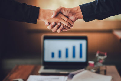 Cropped image of business colleagues shaking hands in office