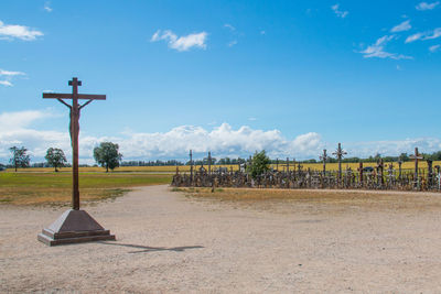 Cross on field against sky