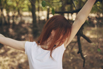 Rear view of woman with arms raised