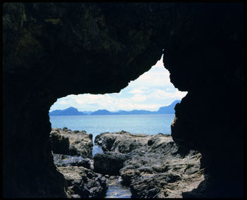 Rock formations by sea against sky