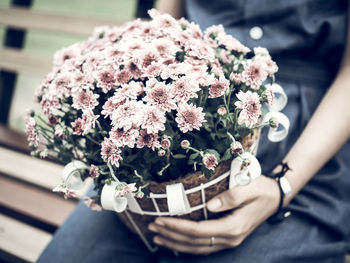 Midsection of woman holding pink flowers bouquet