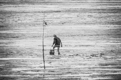 Rear view of man fishing in sea