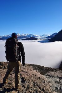 Rear view of man walking on snow covered mountain