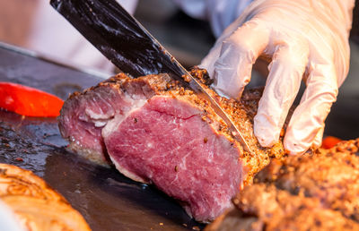 Close-up of man preparing food on barbecue grill