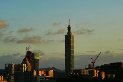 Illuminated cityscape against sky during sunset