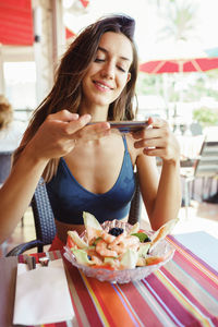 Young woman sitting on table at restaurant