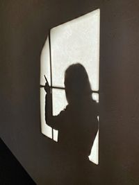 Shadow of person and window on wall