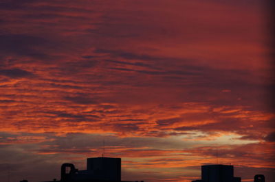 Low angle view of silhouette building against sunset sky