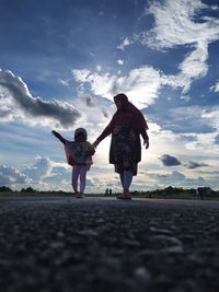 Full length of women standing on landscape against sky