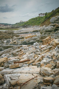 Scenic view of rocks at beach against sky