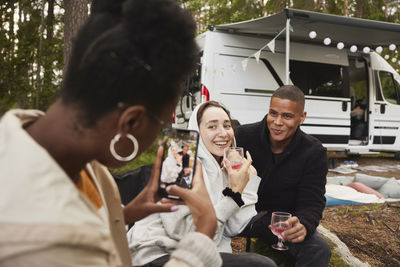 Friends having fun in front of camper van