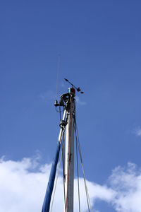 Sailboat rigging including radio antenna and navigation lights against a blue sky 