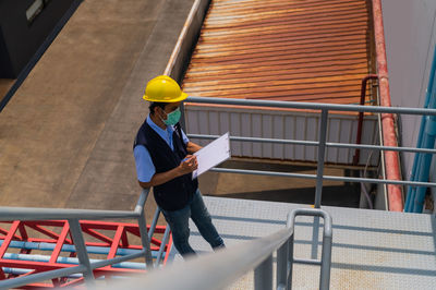 Man holding umbrella at construction site