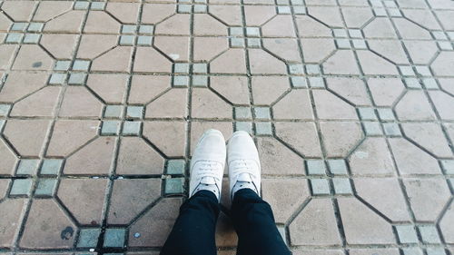 Low section of person standing on tiled floor