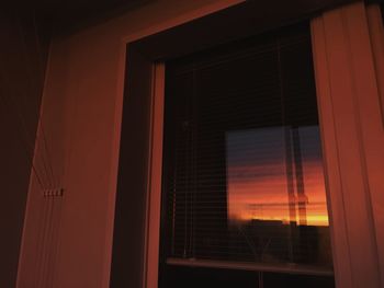 Building seen through window during sunset