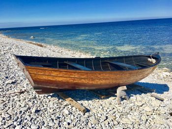 Boats moored on sea shore against sky