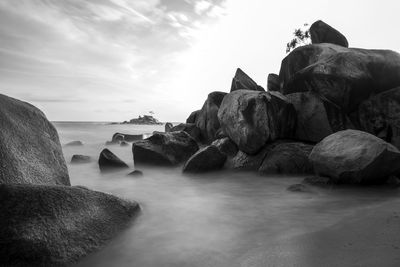 Rocks on beach against sky