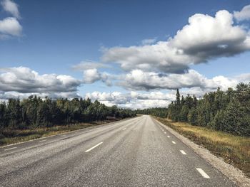 Road amidst trees against sky