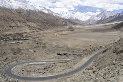 Winding curvy rural road with light trail from headlights leading through ladakh in india.